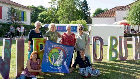 Netzwerk Blankenburg: Teilnehmende des Netzwerks positionieren sich mit einem Plakat für mehr Demokratie in Blankenburg.