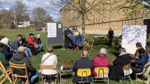 Dorf mit Zukunft aus Lippstadt: in einem Garten sitzt eine Gruppe von Menschen auf Stühlen vor Flipcharts und diskutiert.